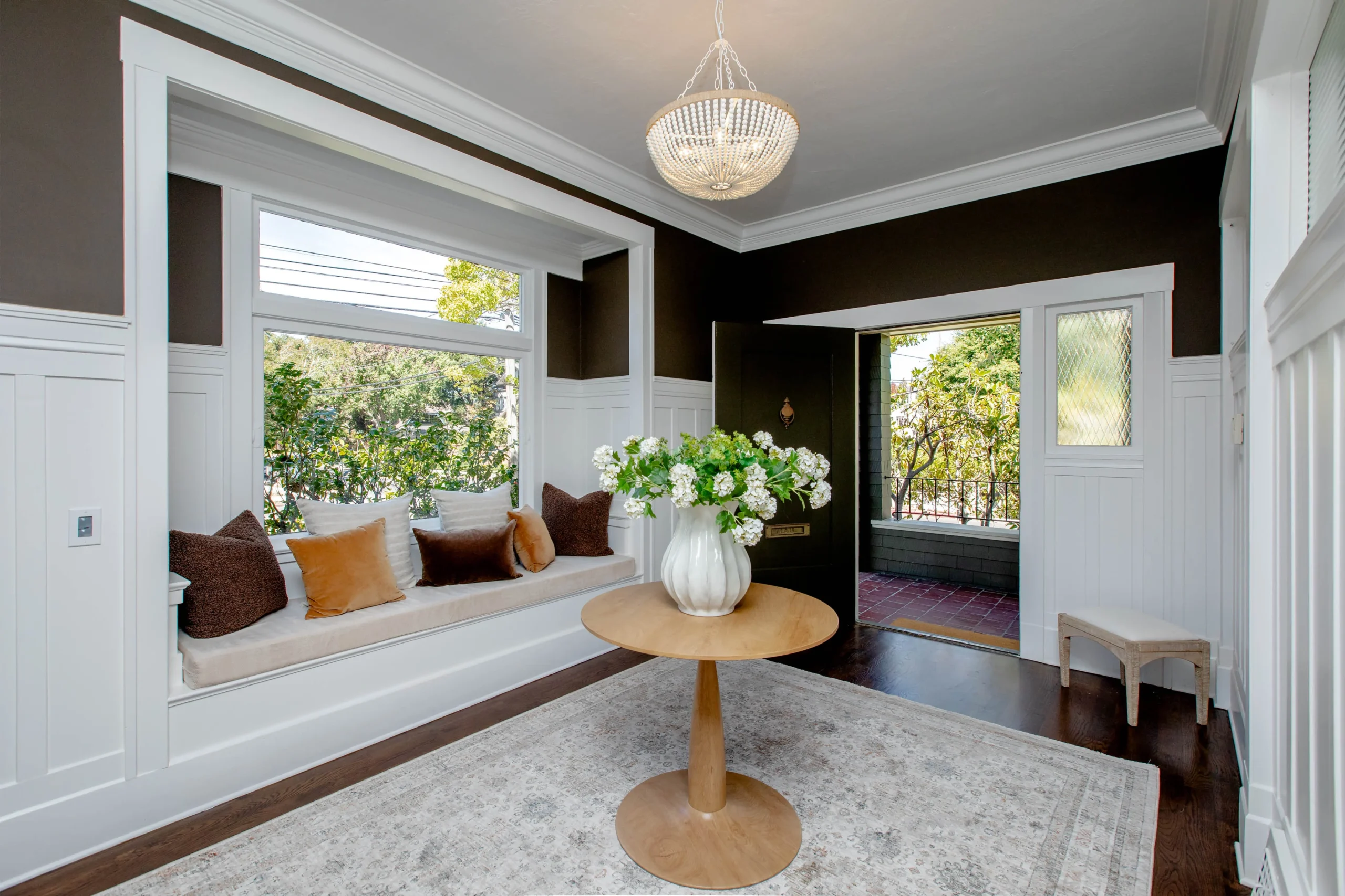 Bright living room with large window seat and elegant decor.