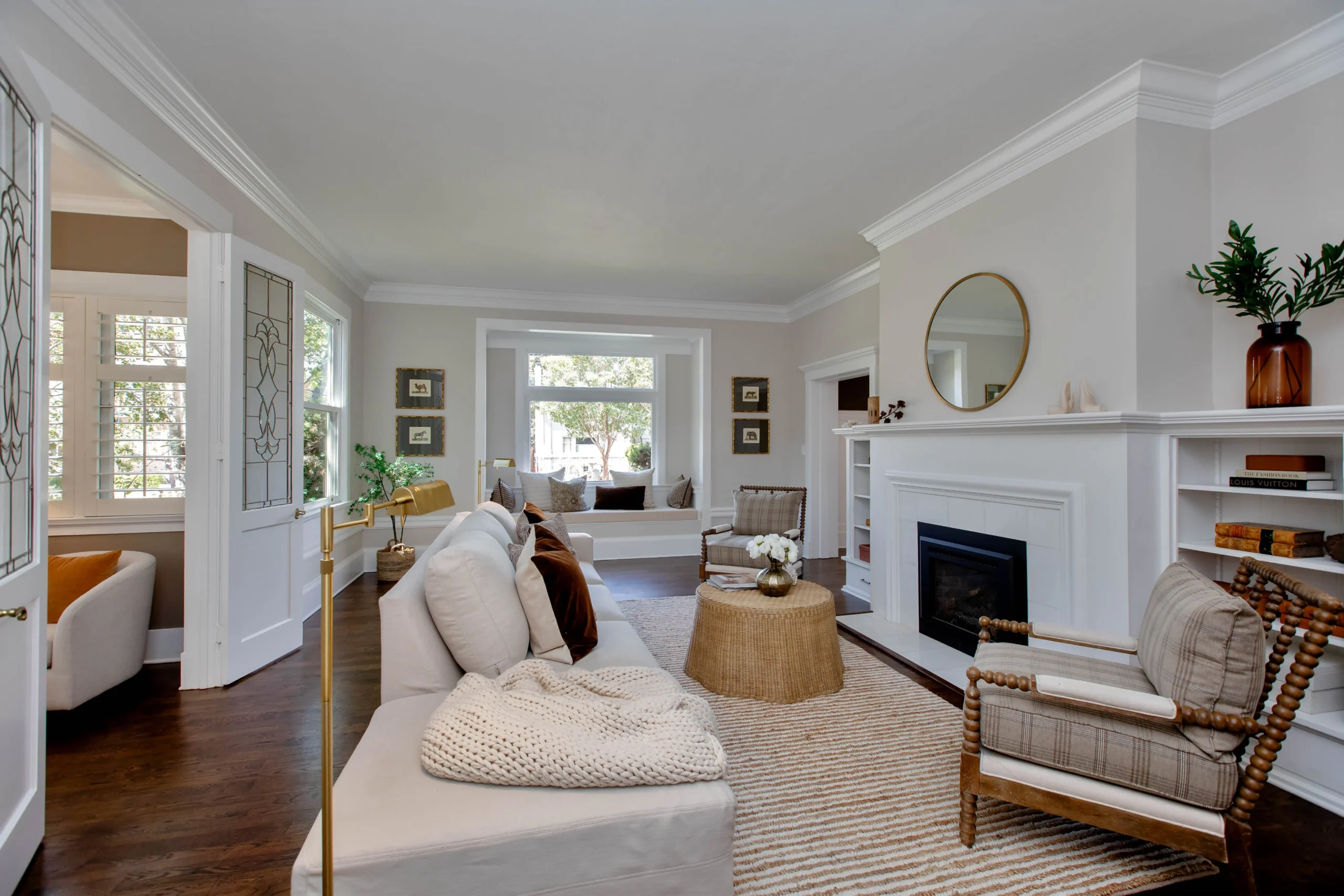 Elegant living room with white walls, fireplace, and cozy seating area.