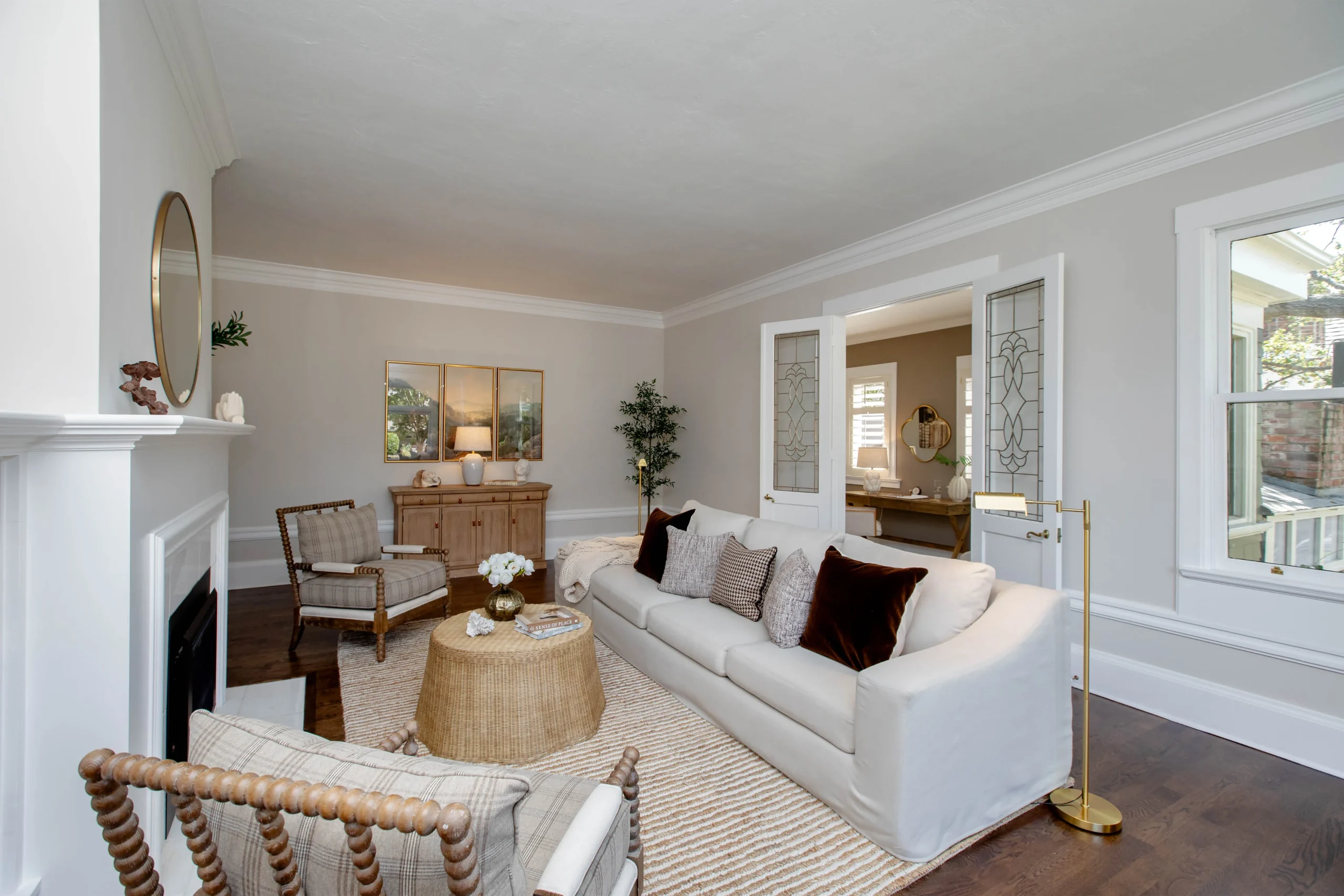 Bright living room with white walls, large window, and cozy furniture.