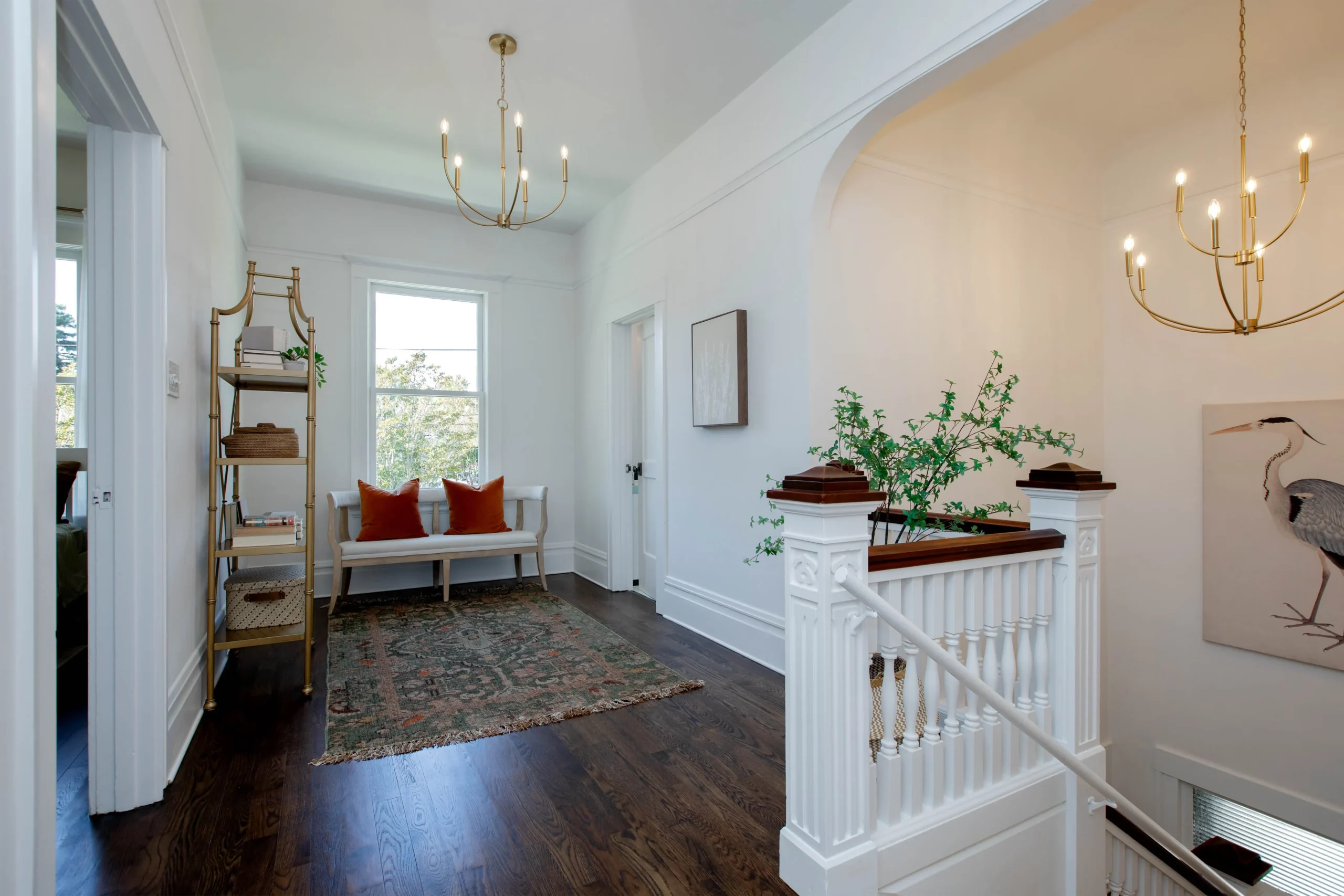 Bright, elegant hallway with white walls, wooden floors, and modern decor.