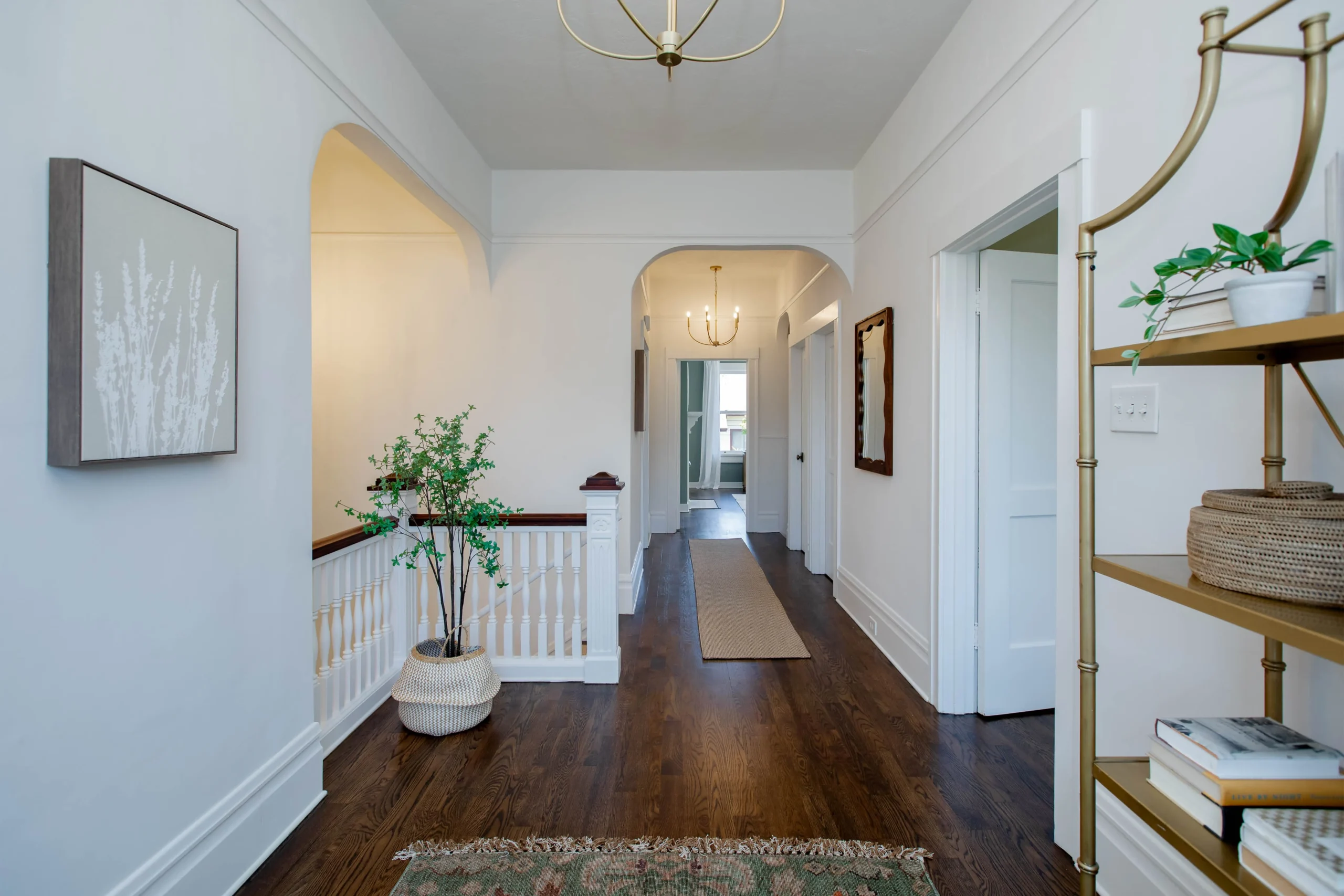 Bright, airy hallway with white walls and wooden flooring.