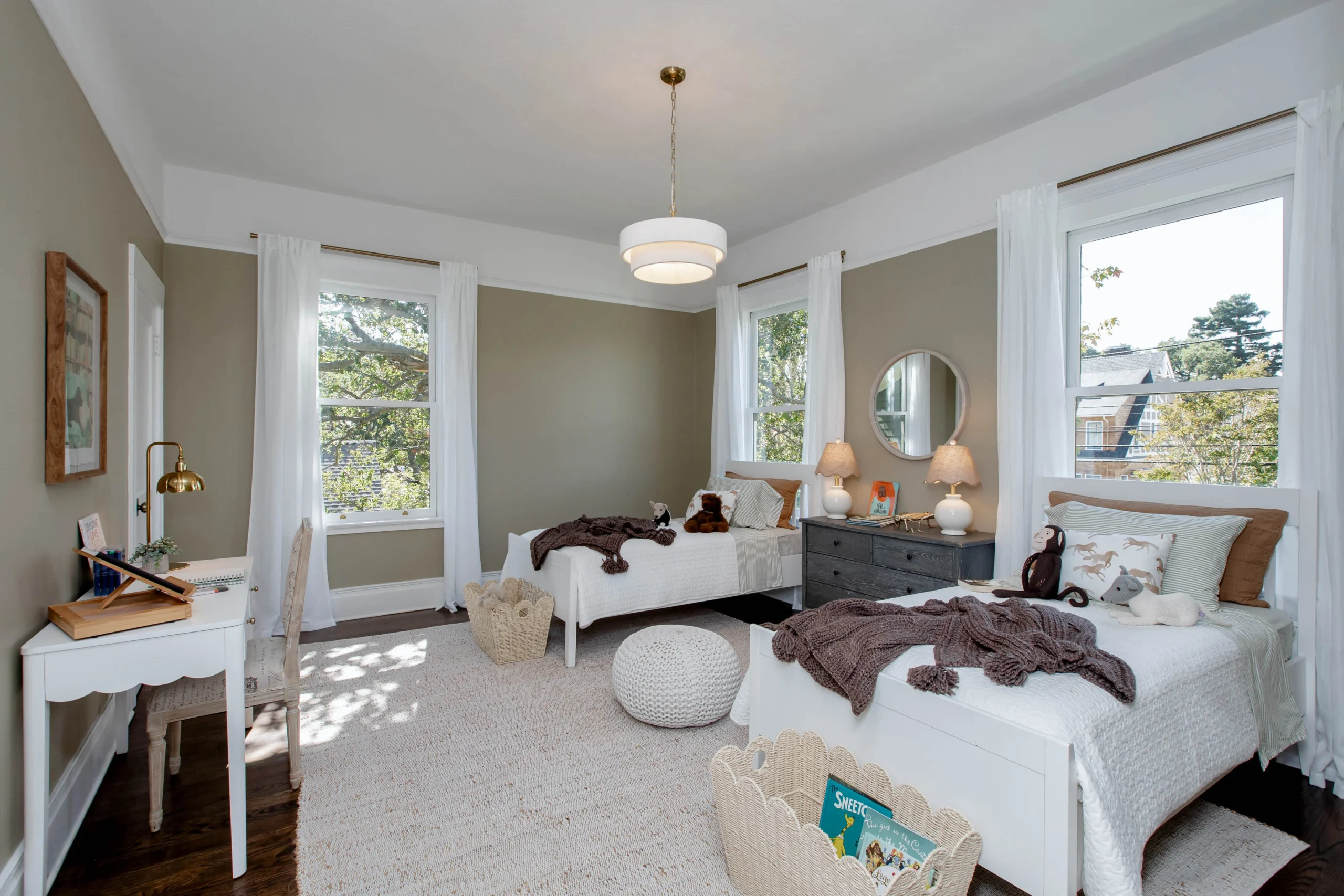 Bright bedroom with two white beds, large windows, and cozy decor.