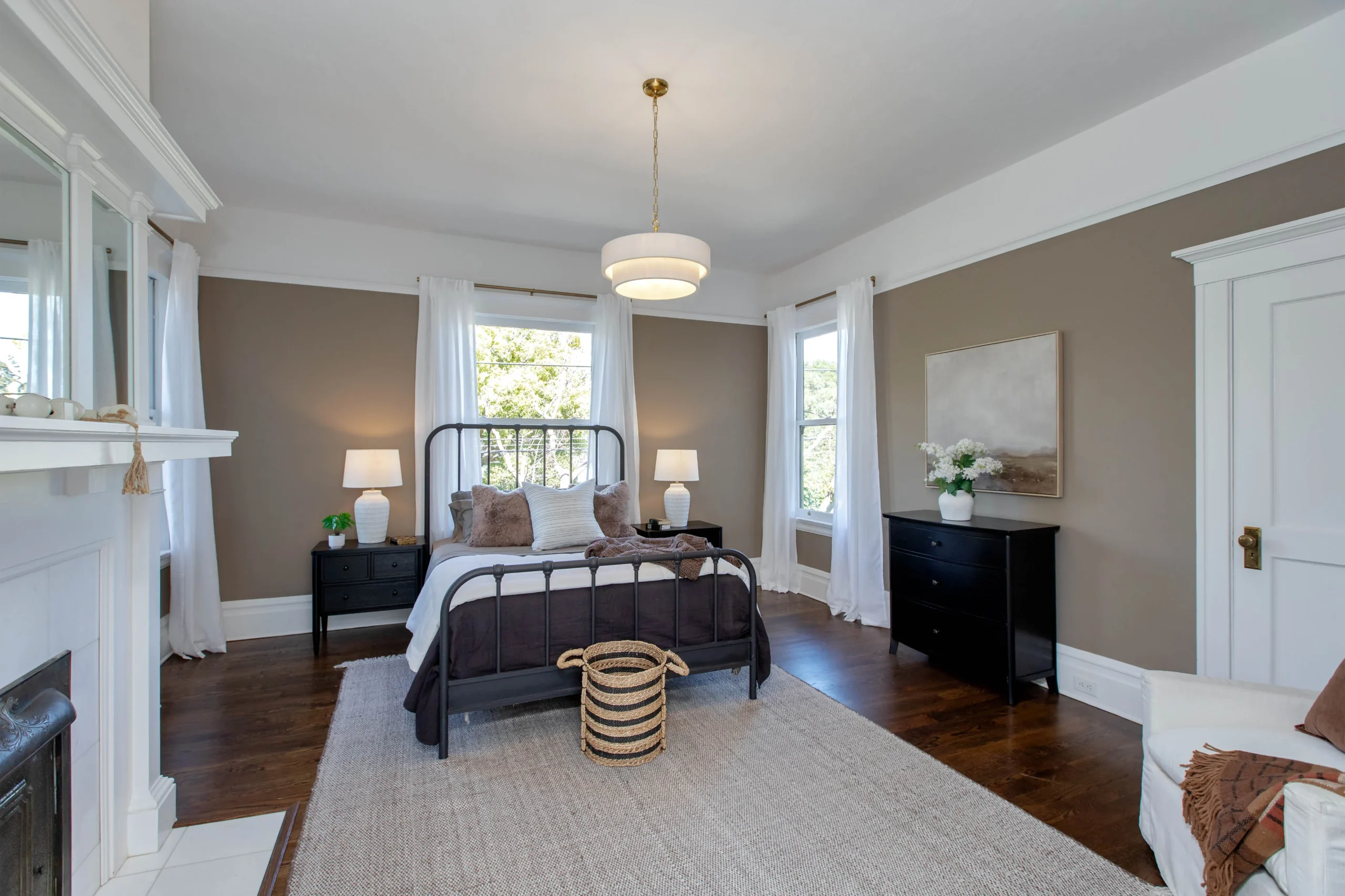 Spacious bedroom with large windows, modern decor, and cozy furnishings.