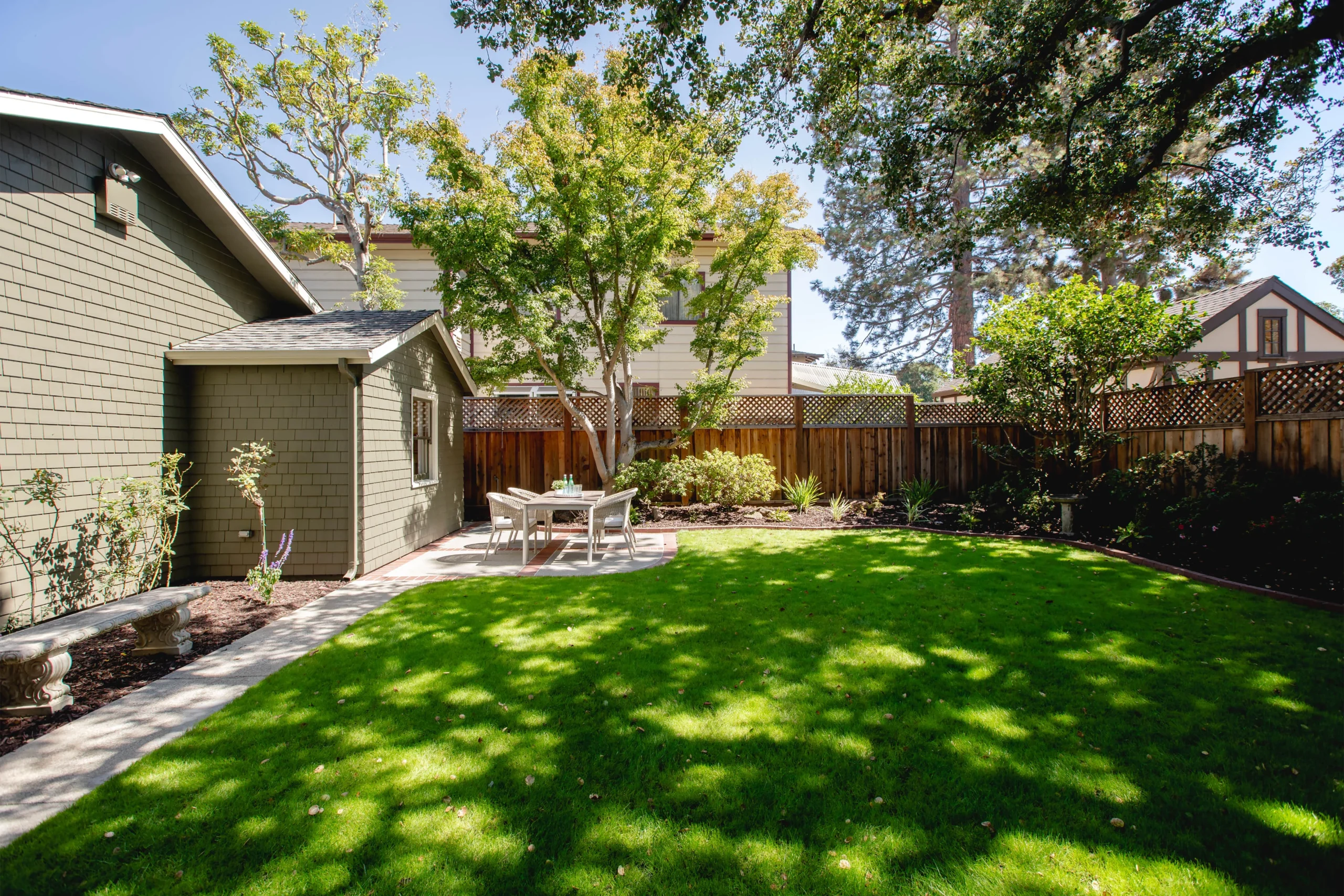 Beautiful backyard with lush green lawn and mature trees.