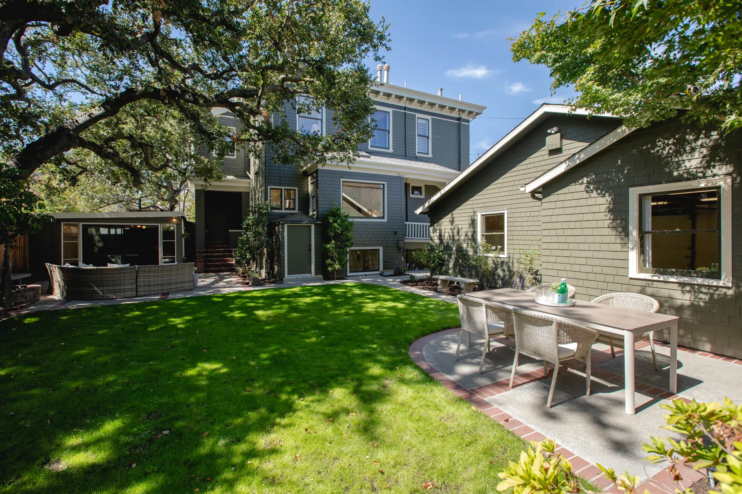 Beautiful backyard with lush green lawn and outdoor dining area.