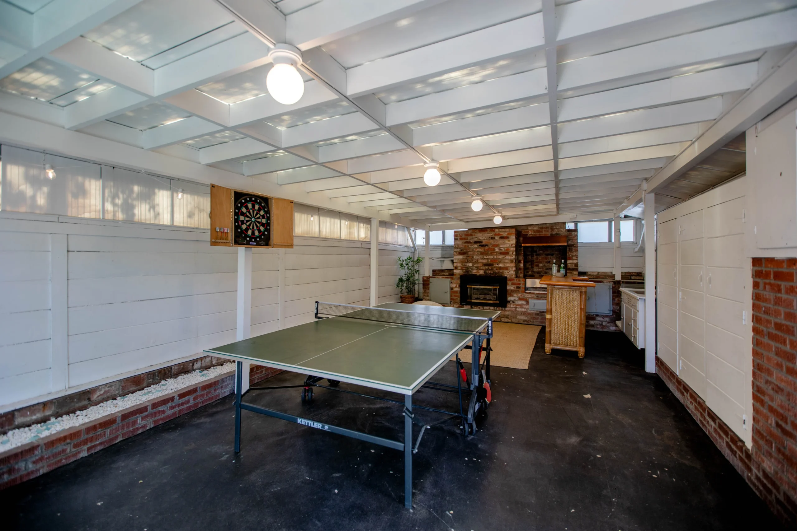 Indoor recreational space with ping pong table and cozy fireplace.