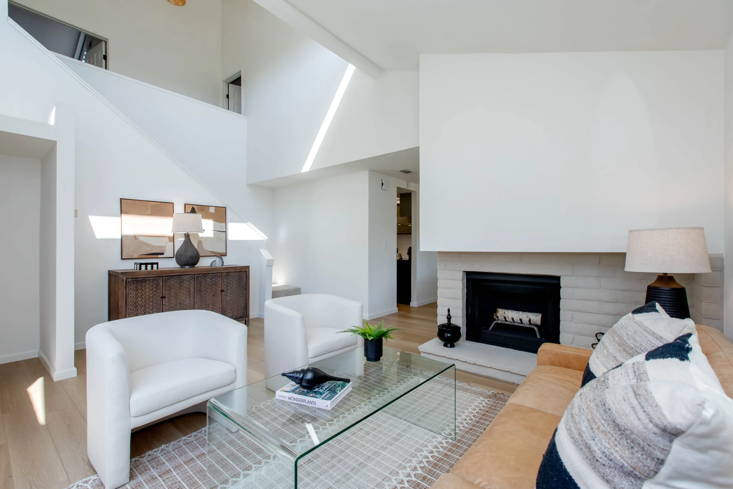 Modern living room with white walls, fireplace, and minimalist furniture.