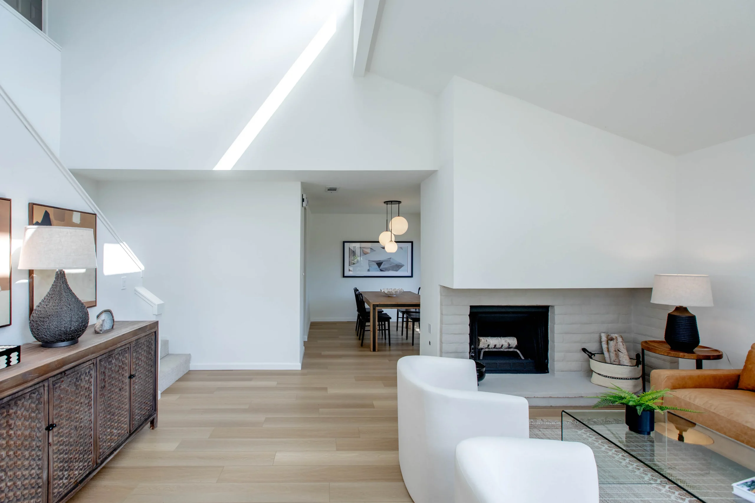 Modern living room with white walls, fireplace, and minimalist furniture.