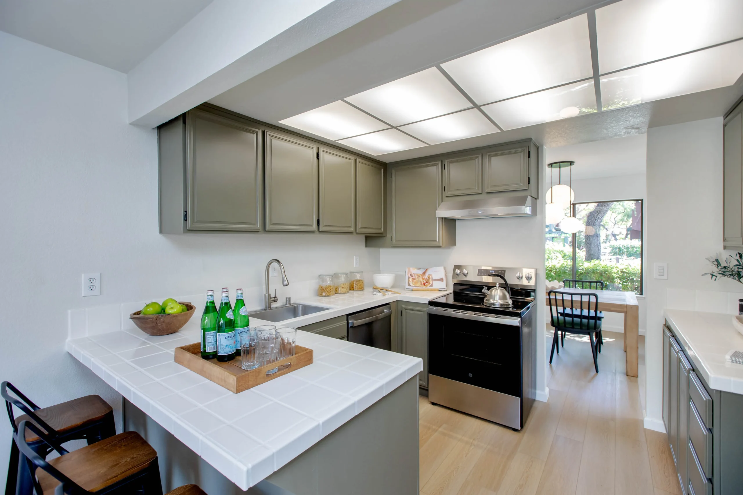 Modern kitchen with gray cabinets and white countertops.